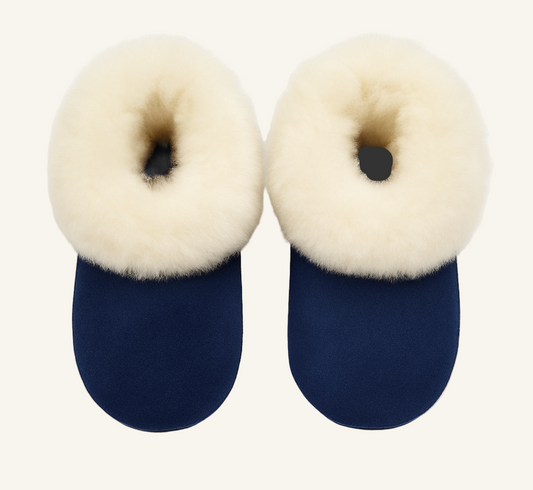 Pair of navy blue slippers with cream fur on a white background